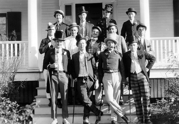 Group of students pose in top hats and tails