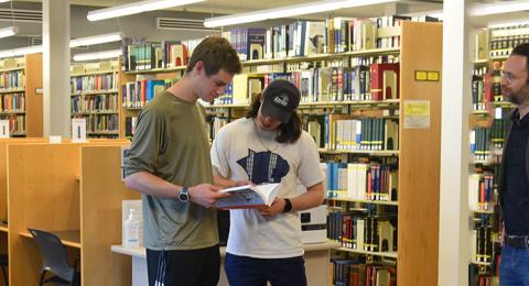 Two students standing with librarian in Engineering library