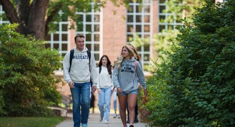 students walking with Dimond Library in the background