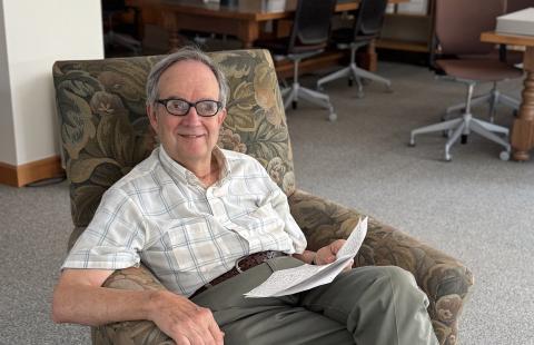 Professor John E. Carroll sitting in the University Archives reading room in Dimond Library