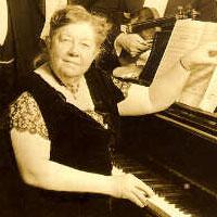Amy Beach seated at piano
