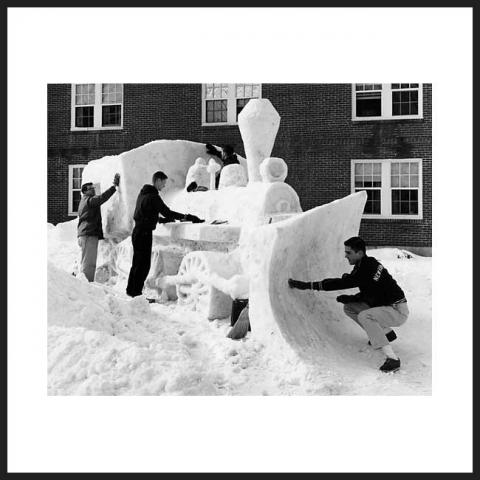 student building a train snow sculpture
