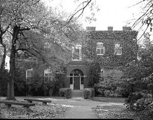 Conant Hall covered in ivy with benches in the foreground.