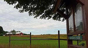 View of barn at Kingman Farm from Knox Marsh Road parking lot with sign in foreground, July 2016.