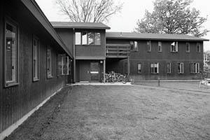 Sackett House with windows open and bicycles under balcony.