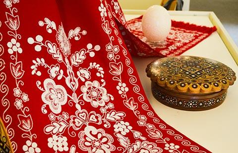 Ukranian folk art items from exhibit including textiles, a carved wooden box, and pysanka