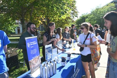 Library staff talking to students at an outdoor event