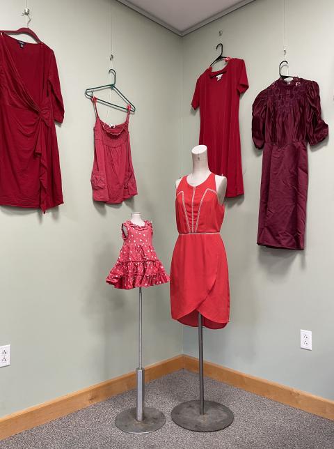Red dresses hanging on the wall and on mannequins from the No More Stolen Sisters exhibit