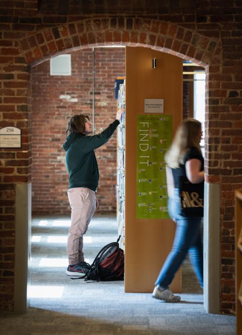 students browsing Manchester Library book stacks